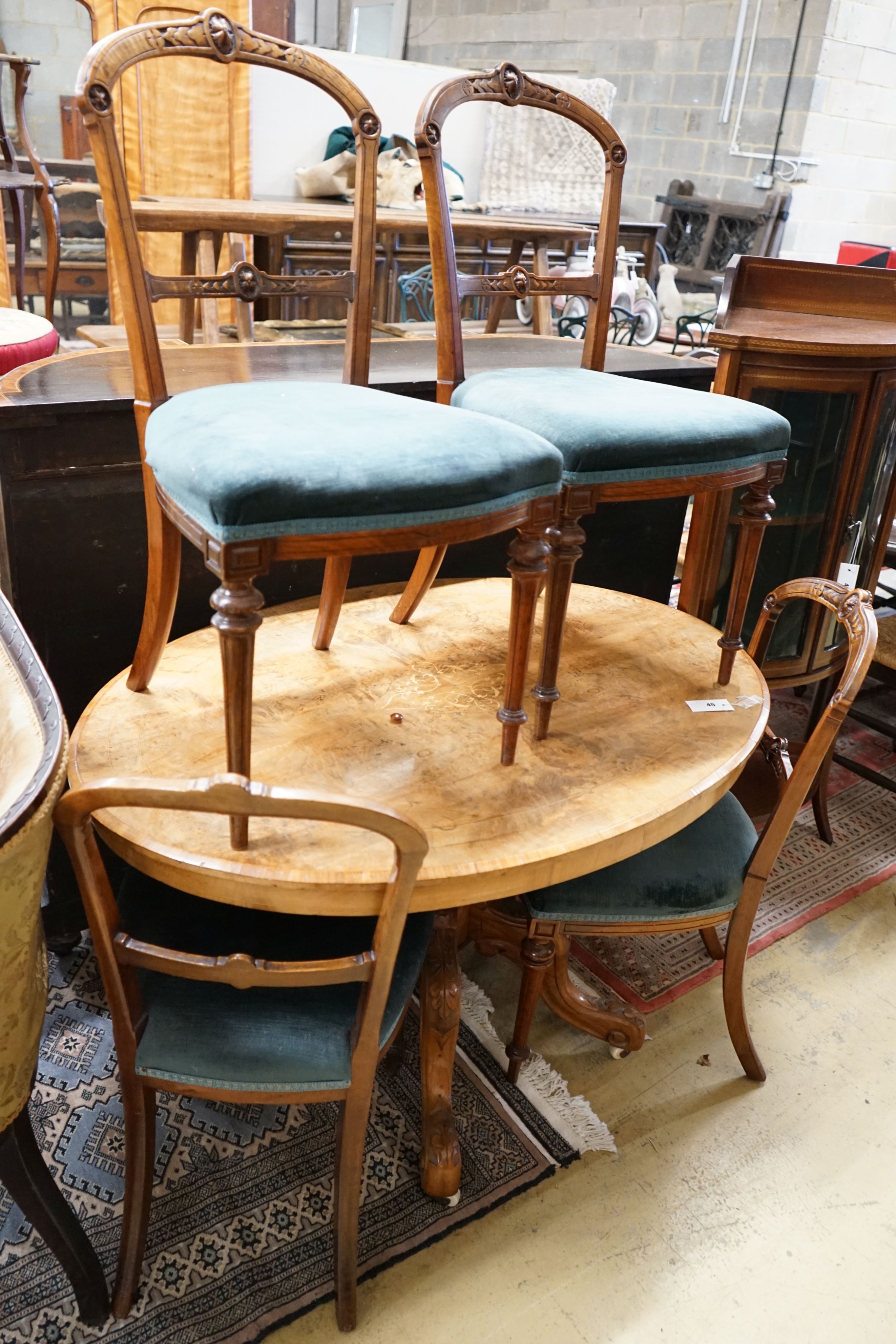 A Victorian burr walnut oval topped loo table, width 120cm, depth 85cm, height 70cm together with four Victorian walnut dining chairs (5)